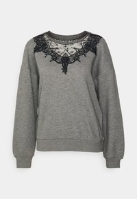 Sweatshirt gris avec un détail en dentelle noire autour de l'encolure. Texture douce avec des manches longues et des poignets et un ourlet côtelés.