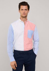 Langsleeve button-up shirt met een gesplitst ontwerp: wit en lichtblauw aan de ene kant, roze aan de andere kant, met een borstzak in lichtblauw.