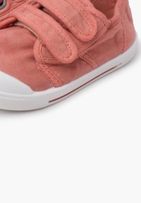 Korallivärviline kangast jalats, millel on kaks Velcro rihma, valge kummist tald ja kerge õmblusdetail.