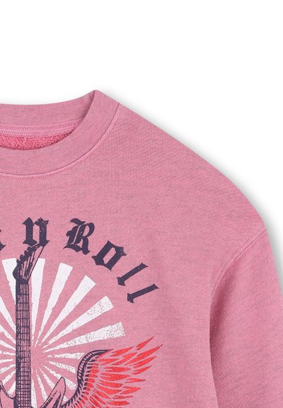 Roze sweatshirt met een grafisch ontwerp van een elektrische gitaar, rode vleugels, witte stralen en de tekst "Rock y Roll" in zwart gotisch lettertype.