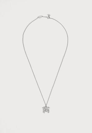 Collier chaîne en argent avec un petit pendentif en forme de grenouille sur un fond uni clair, avec un fermoir mousqueton et une chaîne de rallonge.