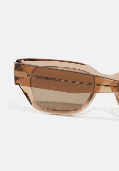 Bruna plastsolglasögon med geometrisk design, utrustade med en tjock ram och tonade linser, accentuerade med "DOLCE & GABBANA"-logotyp.