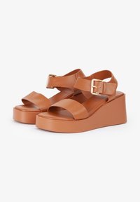Sandali platform in pelle marrone con fasce larghe, dettaglio fibbia e suola a zeppa spessa. Texture liscia e design minimalista.