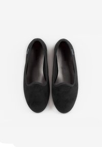 Scarpe slip-on in suede nero con una texture liscia, punta arrotondata e bordi elasticizzati. L'interno presenta un sottile dettaglio di branding.