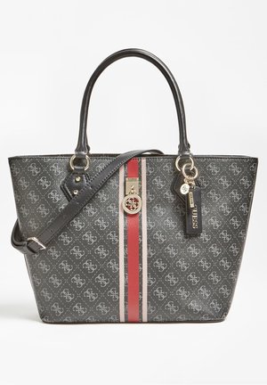 Zwart- en grijze Guess draagtas met overal logo-print, rode en beige verticale strepen, dubbele handvatten, verstelbare schouderriem en merkbedeltjes.