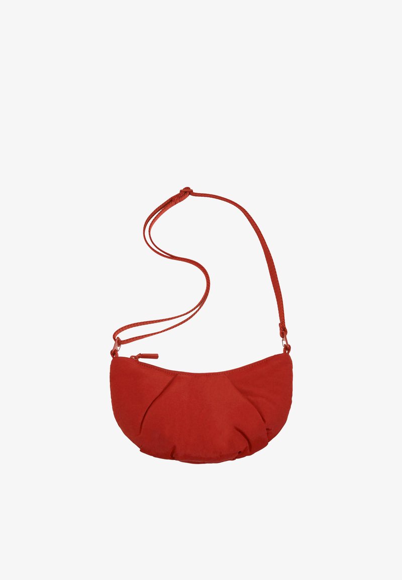 Petit sac d'épaule rouge en forme de croissant avec une longue bandoulière réglable et une fermeture éclair.