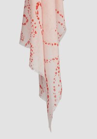 Roze sjaal met een rood abstract patroon, rafelige randen en lichte stof, gedrapeerd om het ontwerp en de textuurdetails te tonen.