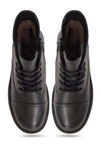 Par de botas de cuero negro con cordones y cremalleras laterales, con un suave forro de pelo marrón, vistas desde arriba.