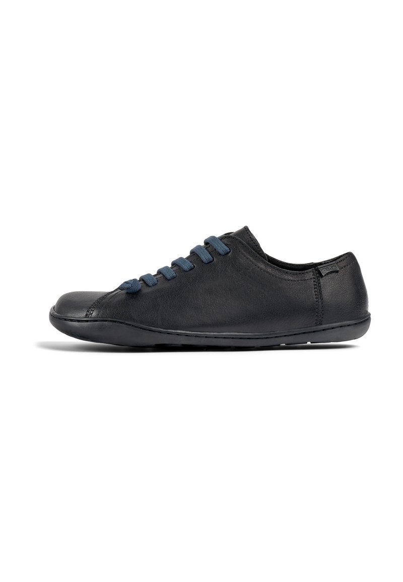 Svart lädersneaker med rundad tå, utsmyckad med blå mockasnören, låg profil och minimala sömmar på sidorna.