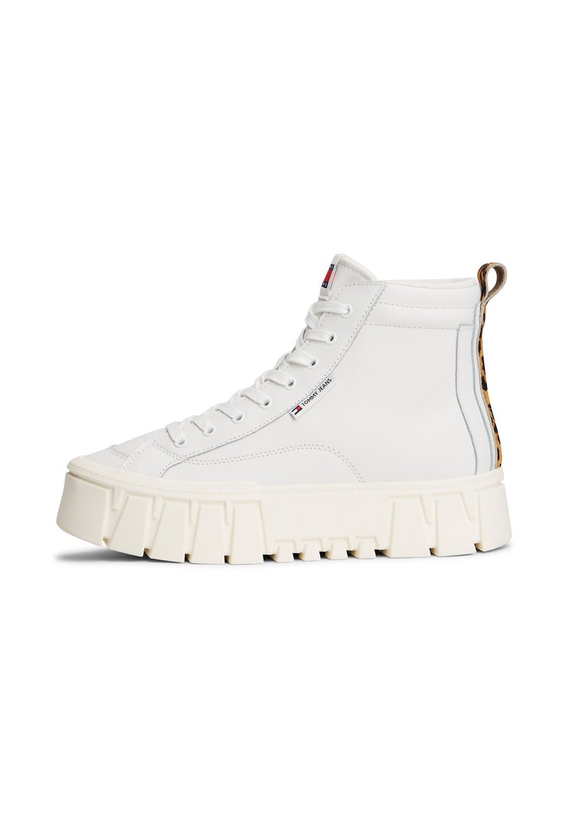 Baskets montantes en cuir blanc avec une semelle épaisse beige, présentant un accent en imprimé léopard au talon et un design à lacets.