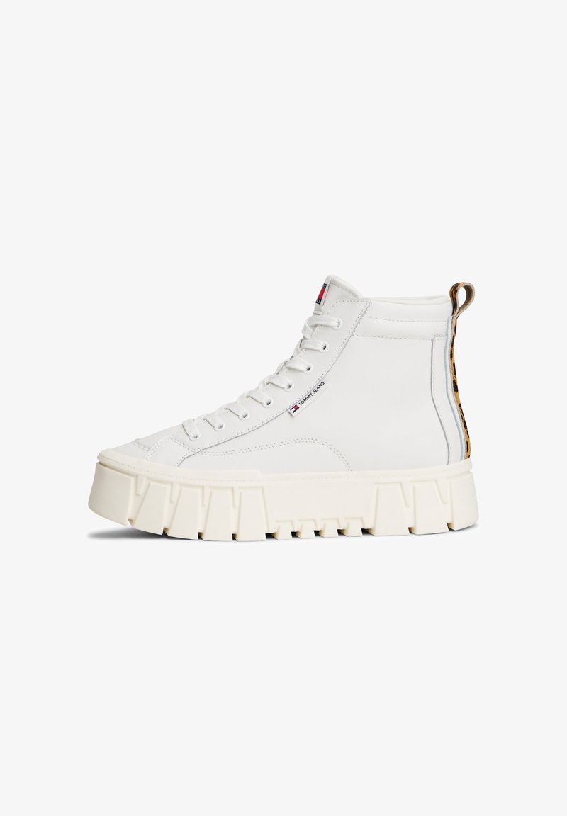 Baskets montantes en cuir blanc avec une semelle épaisse beige, présentant un accent en imprimé léopard au talon et un design à lacets.