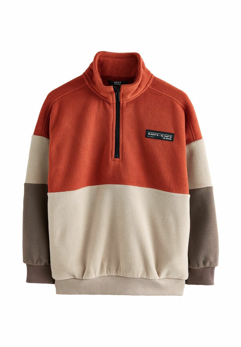 Colour-block fleece pullover with rust orange, beige, and brown panels, zip collar, cuffed sleeves, and a patch with coordinates on chest.