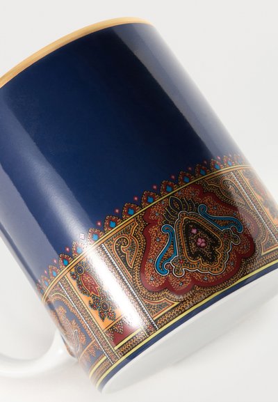 Tasse en céramique bleue avec un motif complexe en forme de banderole de motifs cachemire et floraux en or, rouge et turquoise autour de la base et du bord.