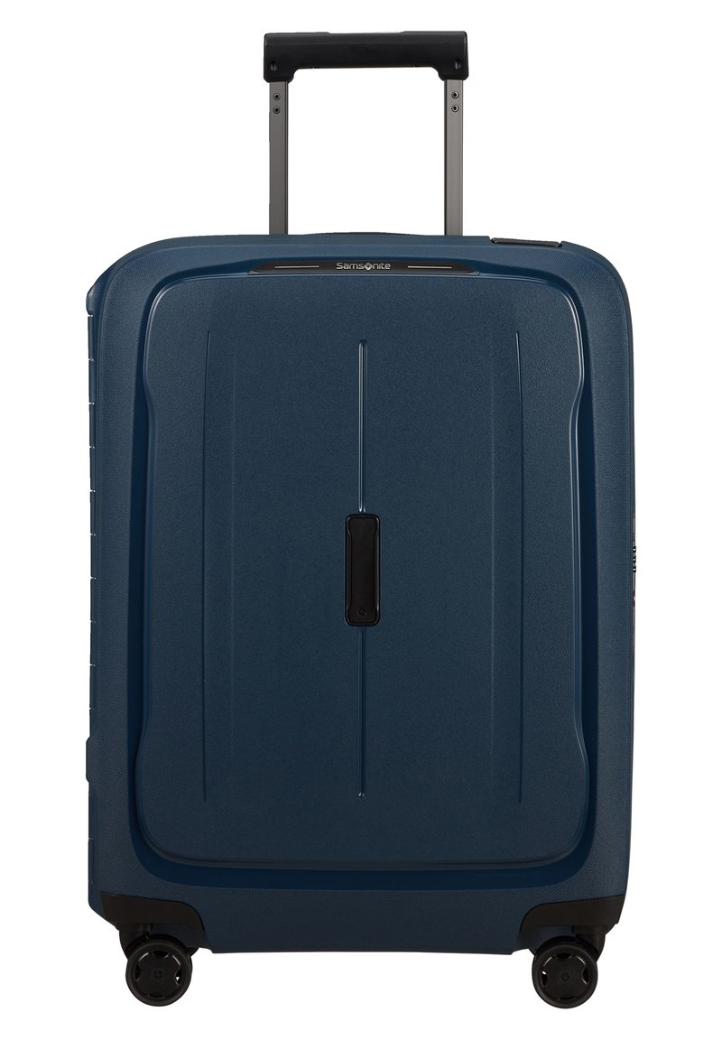 Valise rigide de couleur bleu foncé, avec une surface texturée, une poignée rétractable et quatre roues pivotantes noires. Design minimaliste avec des lignes verticales.