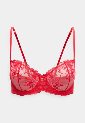 Reggiseno in pizzo rosso con coppe trasparenti, ricamo floreale, spalline regolabili e fiocco centrale. Materiale morbido e strutturato con dettagli intricati.