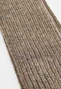 Brauner Strickstoff mit einem strukturierten, gerippten Design, das vertikale Linien und ein weiches, warmes Erscheinungsbild aufweist.