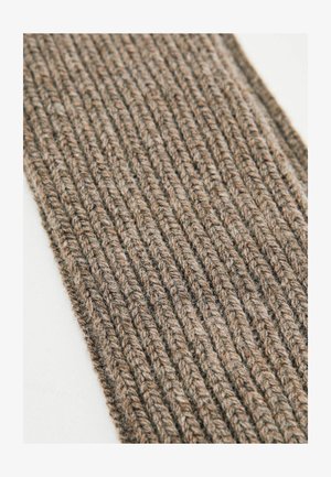 Pruun kudumine, millel on tekstuuriga ribakujundus, vertikaalsed jooned ja pehme, soe välimus.