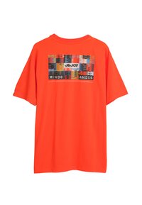 Oranje katoenen T-shirt met een grafische print, voorzien van tekst en kleurrijke abstracte patronen. Losse pasvorm met korte mouwen en ronde hals.