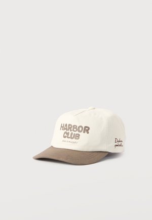 Weißer und brauner Baseballcap mit dem Text "Harbor Club Bar & Market" auf der Vorderseite und "Dryborn specialties" an der Seite.