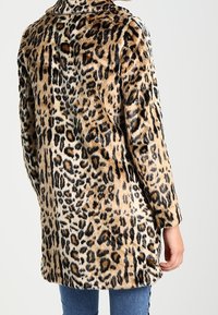 Kabát z umělé kožešiny s leopardím vzorem, měkkou texturou, dlouhými rukávy a zaobleným límcem, s délkou do poloviny těla a zvýrazněnými švy.