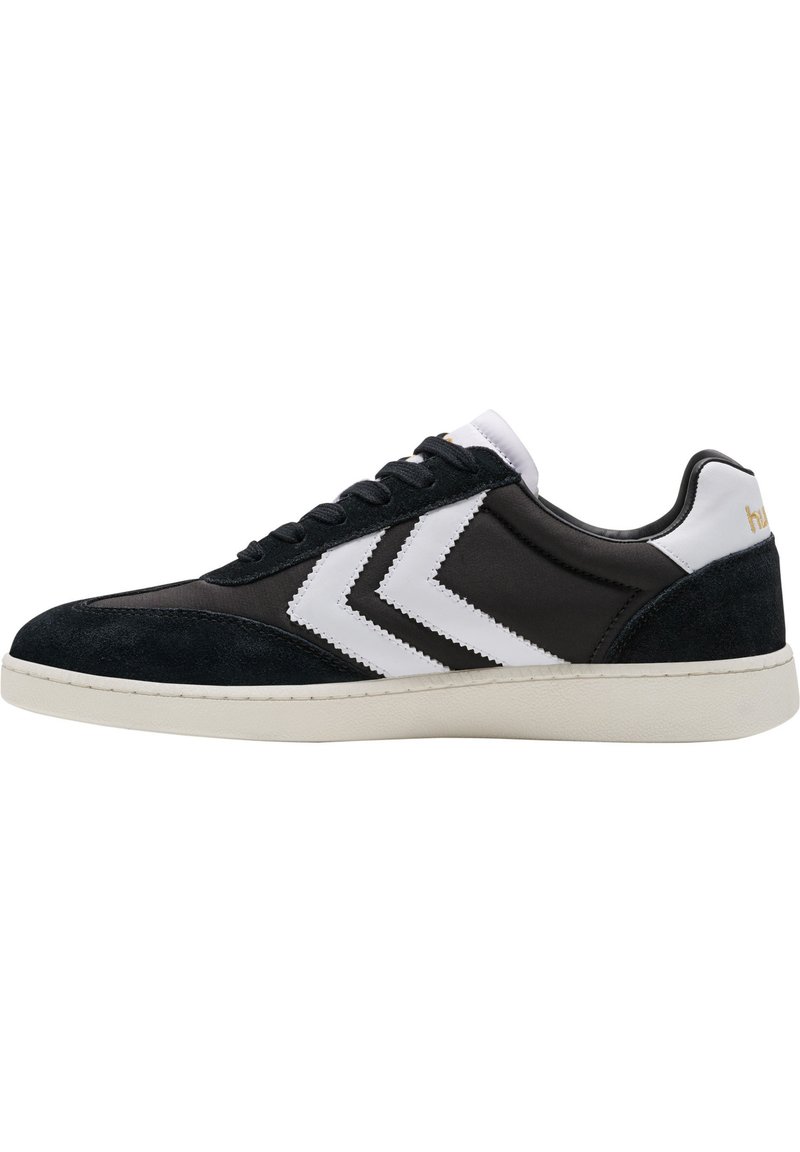 Sapatilhas preto e branco com um cabedal em camurça e sintético, de design baixo, listras em zig-zag contrastantes e sola em borracha.