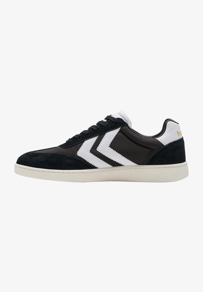 Sapatilhas preto e branco com um cabedal em camurça e sintético, de design baixo, listras em zig-zag contrastantes e sola em borracha.