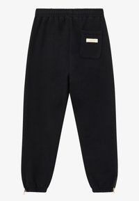 Sorte sweatpants med snor i taljen, elastiske nederkanter og lynlåse i nederste del. Udstyret med en enkelt baglomme med et skilt. Blød tekstur.