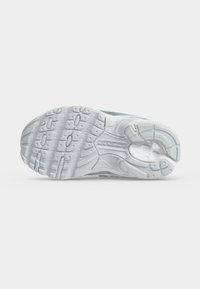 Σόλα λευκού αθλητικού παπουτσιού New Balance με υφή και ανάγλυφο το όνομα της μάρκας στο κέντρο.