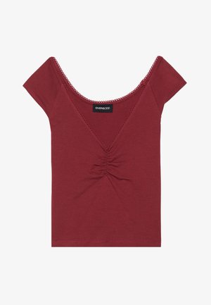 Lilla sobiv top lühikeste varrukatega, ümar kaelus, kokku kogutud keskdetail ja laineline äär kaeluse ja varrukate ääres.