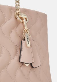 Borsa a tracolla trapuntata rosa chiaro con catena, caratterizzata da hardware dorato e un'etichetta con il logo GUESS. Pelle strutturata con dettagli lisci.