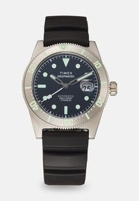 Montre Timex Deepwater avec boîtier en titane, bracelet en caoutchouc noir, cadran noir, marqueurs lumineux, affichage de la date et lunette unidirectionnelle.
