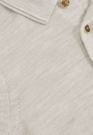 Helebeežist kaelusega särk, millel on tekstuuriga kudum ja kuldsed nööbid. Suurendatud vaade, mis toob esile õmbluse ja kangaste detailid.