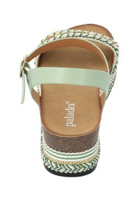 Sandalias de plataforma verdes con una correa trenzada tejida, presentando una parte superior de color menta suave, plantilla acolchada y base marrón texturizada.