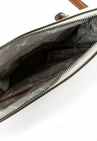 Czarna torebka na zamek błyskawiczny z brązowymi skórzanymi akcentami, z szarym wnętrzem wyściełanym materiałem w wzory kółek i kropek.