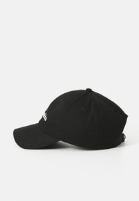 Casquette de baseball noire en coton avec un visière courbée. Comprend un texte brodé à l'avant et des trous de ventilation sur le dessus.
