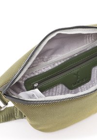 Borsa in tessuto verde con una trama texturizzata, zip argentata e fodera grigia. All'interno c'è una piccola tasca con zip verde e un'etichetta.