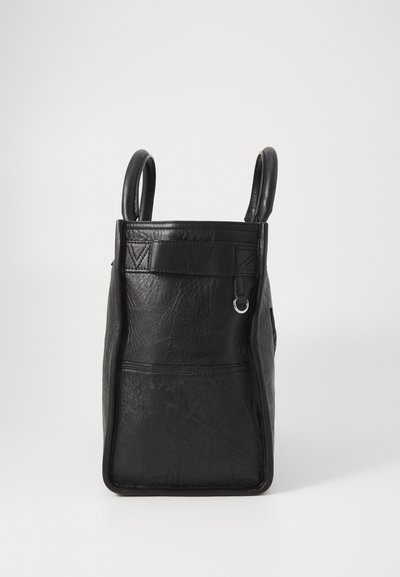 Black leather bag with two rounded handles, rectangular shape, textured surface, front pocket detail, and a silver hardware loop.