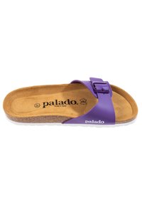 Lila rutschkloss med en bred rem och justerbar spänne. Korkfotbädd på en texturerad vit sula. Har varumärket "palado" i svart.