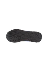 Black rubber outsole with textured grip pattern, featuring wavy grooves and a small circular accent near the center.