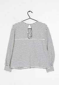 Camisa blanca de manga larga con rayas horizontales azul marino. Presenta una abertura en forma de ojo de cerradura en la parte posterior y puños fruncidos en las mangas.
