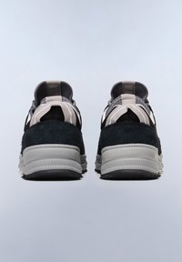 Scarpe sportive nere e grigie con tomaia in tessuto testurizzato, colletto imbottito e suola in gomma spessa e multicolore. Presenta dettagliati accenti di cucitura.