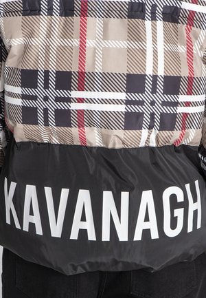 Daunenjacke mit einem karrierten Muster in Beige, Schwarz und Rot, der untere Teil in Schwarz mit großen weißen Buchstaben "KAVANAGH" am Saum.