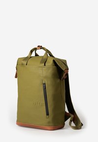 Zaino impermeabile verde con due maniglie superiori, una tasca frontale con zip, base in pelle marrone e spallacci regolabili. Design semplice.