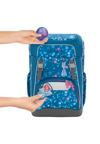 Zaino blu con motivo a pois e stelle rosa, dotato di toppe rimovibili, dettagli grigi e due scomparti con zip.