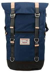 Sac à dos en toile bleu avec fond noir, accents en cuir, deux bretelles ajustables et poche avant zippée. Comprend un patch logo et une fermeture à enroulement.