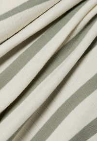 Pasiasta tkanina w naprzemiennych kremowych i jasnooliwkowych kolorach, z teksturowanym splotem i gładką, miękką powierzchnią.