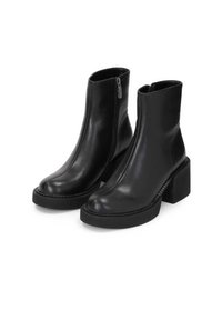 Bottines en cuir noir avec une finition lisse, fermeture éclair sur le côté, bouts arrondis et un talon épais. Détails cousus le long de la semelle.