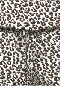 Tkanina s leopardím vzorom so bielym pozadím, na ktorom sú hnedé a čierne škvrny, obsahuje šnúrku na zatvorenie. Mäkká textura, ležérny dizajn.