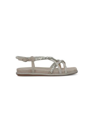 Sandal in beige, piatto, con accenti decorativi in argento, design a cinturino incrociato, cinturino alla caviglia regolabile e suola liscia e texturizzata.