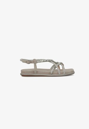Sandal in beige, piatto, con accenti decorativi in argento, design a cinturino incrociato, cinturino alla caviglia regolabile e suola liscia e texturizzata.